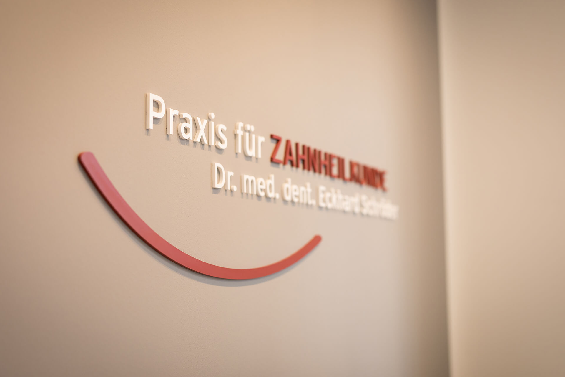 Logo von der Zahnarztpraxis an der Wand - Zahnarztpraxis Dr. Eckhard Schröder in Grimma